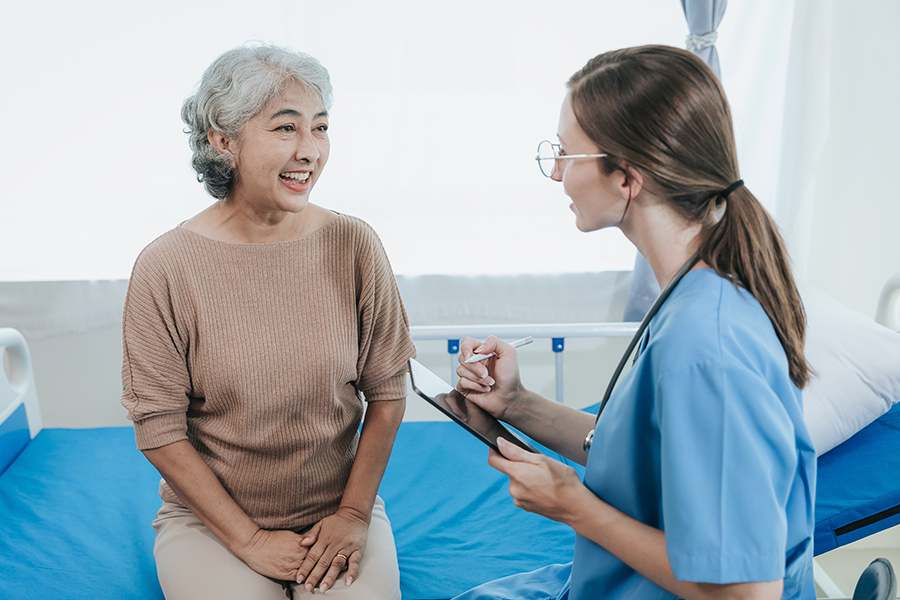 Fotografía de una adulta mayor y una doctora.