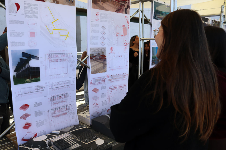 Estudiantes miran poster científico de arquitectura