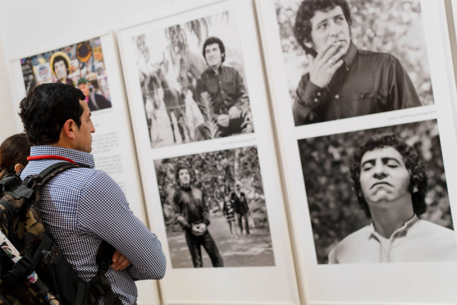 Persona adulta observa las fotos de Víctor Jara en la exposición ubicada en el Espacio Ágora de la Biblioteca Central