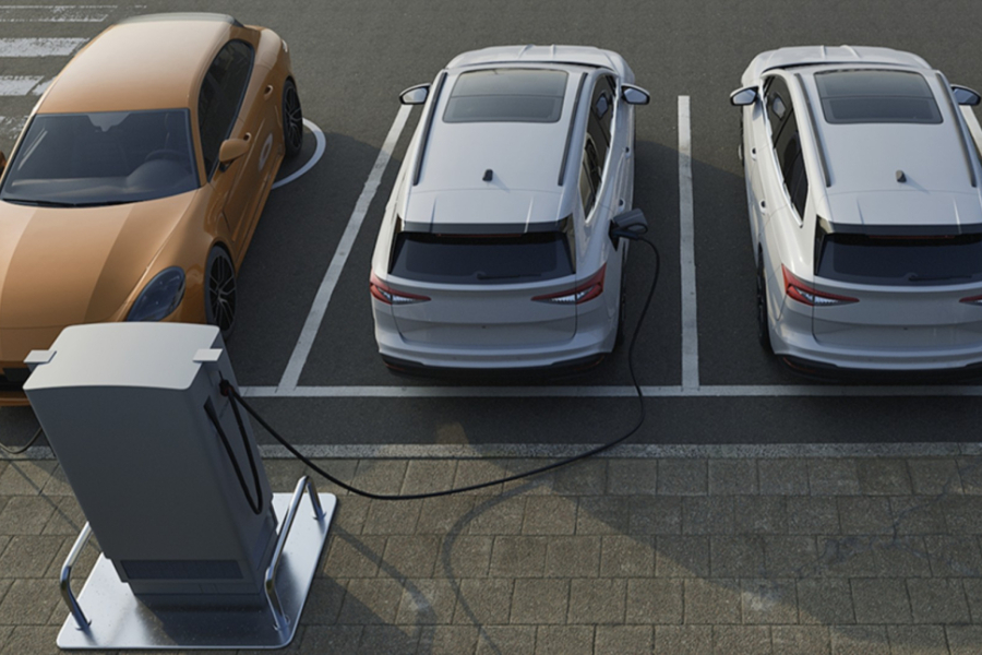 En la imagen aparece un cargador eléctrico y tres automóviles.