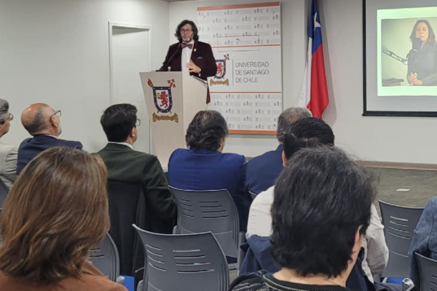 En la imagen se observa al académico Germán Pinto Perry, quien se dirige a la audiencia.