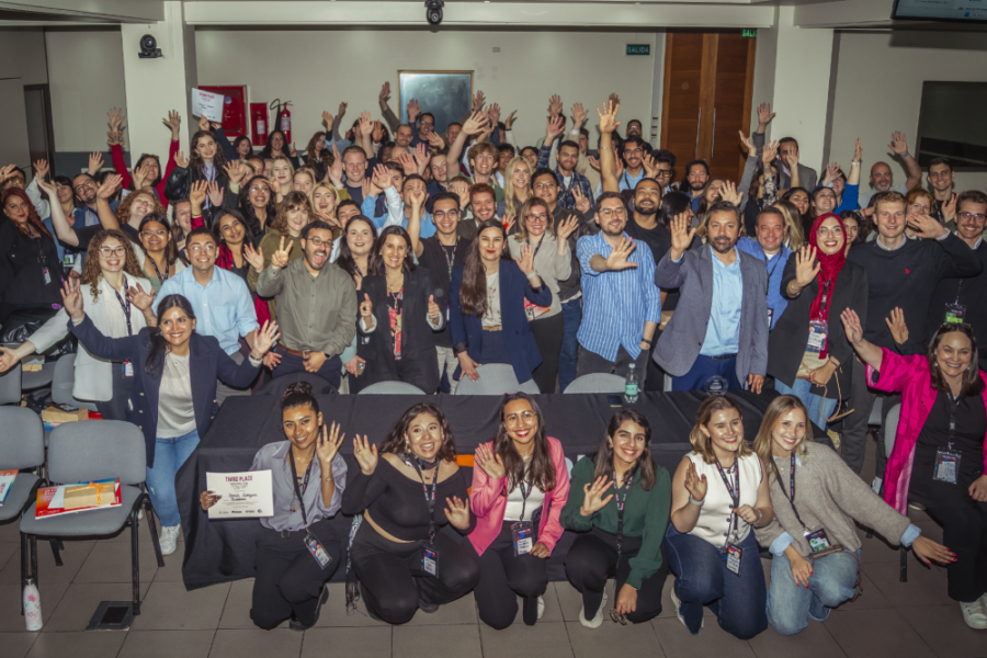 En la imagen aparecen alrededor de 50 personas saludando, son estudiantes de diferentes países que participaron de la actividad