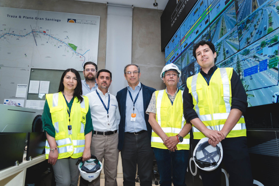 Académicos del DIGEA-Usach posan a la cámara junto a gerentes de la concesionaria Vespucio Norte. Aparecen con cascos blancos y chalecos amarillos de seguridad.