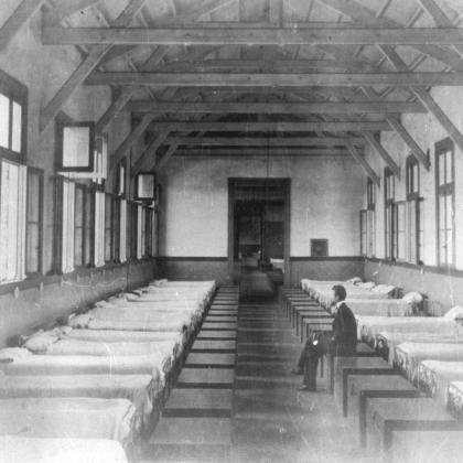 Vista de un hombre sentado en uno de los dormitorios para 300 alumnos de la Escuela de Artes y Oficios.