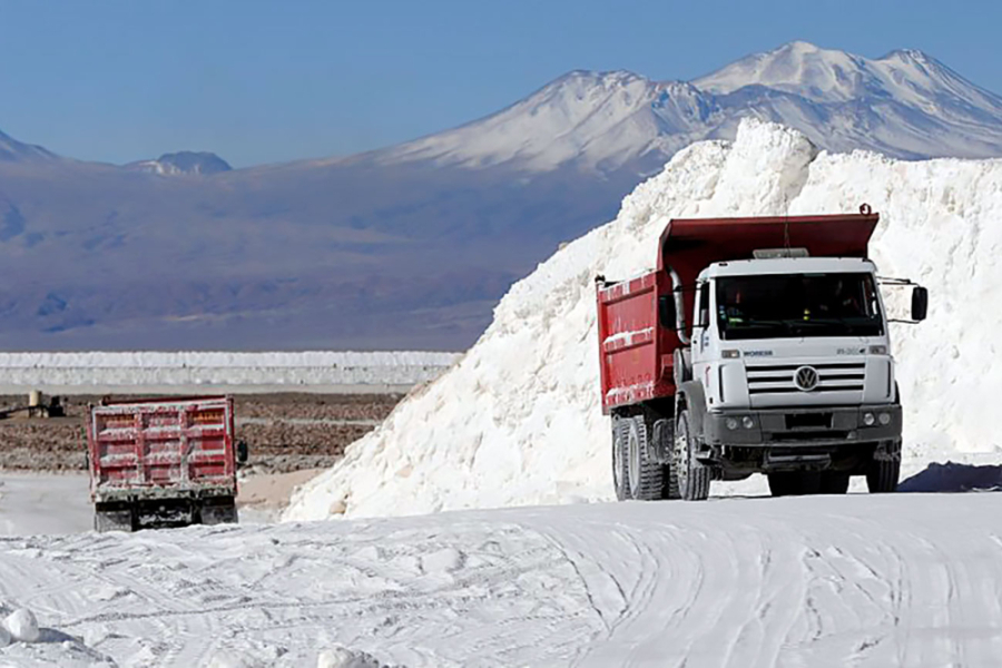 En la imagen aparecen dos camiones mineros transportando litio desde una montaña del mineral- De fondo, la cordillera de los andes.