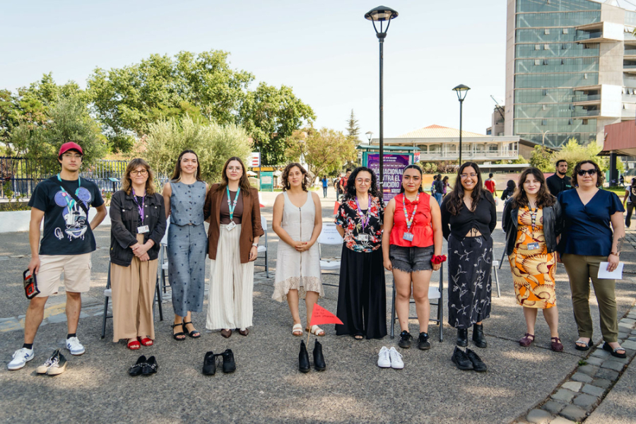 En la imagen aparecen profesionales y dirigente que pertenece al ecosistema de género de nuestra Universidad. Posan en la entrada principal y de fondo se observa el edificio de la Facultad de Administración y Economía.