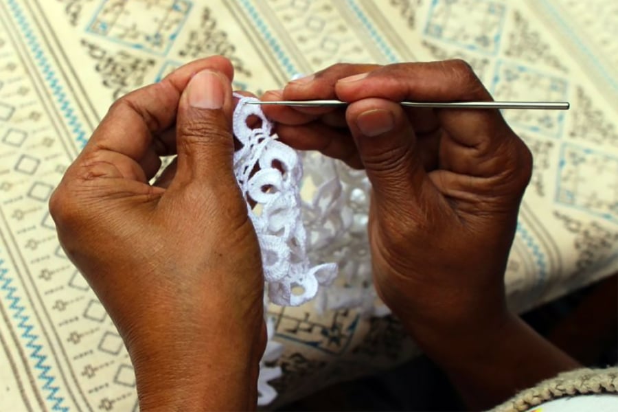 En la imagen aparecen dos manos tejiendo a crochet