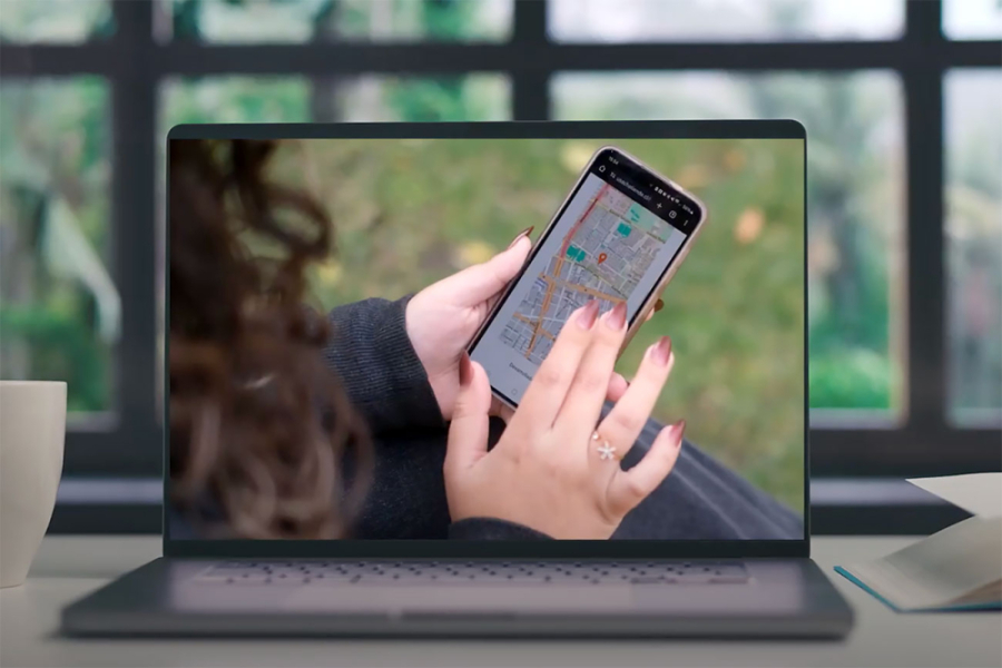 La fotografía muestra un computador que en su pantalla muestra una mano manipulando un celular