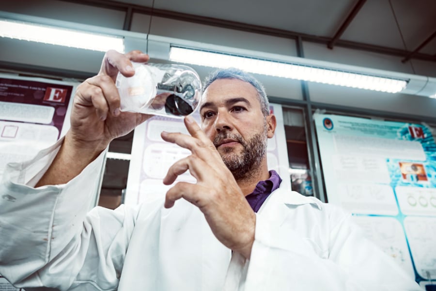 La imagen muestra al académico manipulando instrumentos en un laboratorio