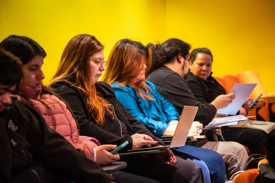 La imagen muestra a docentes sentados frente a su computador personal