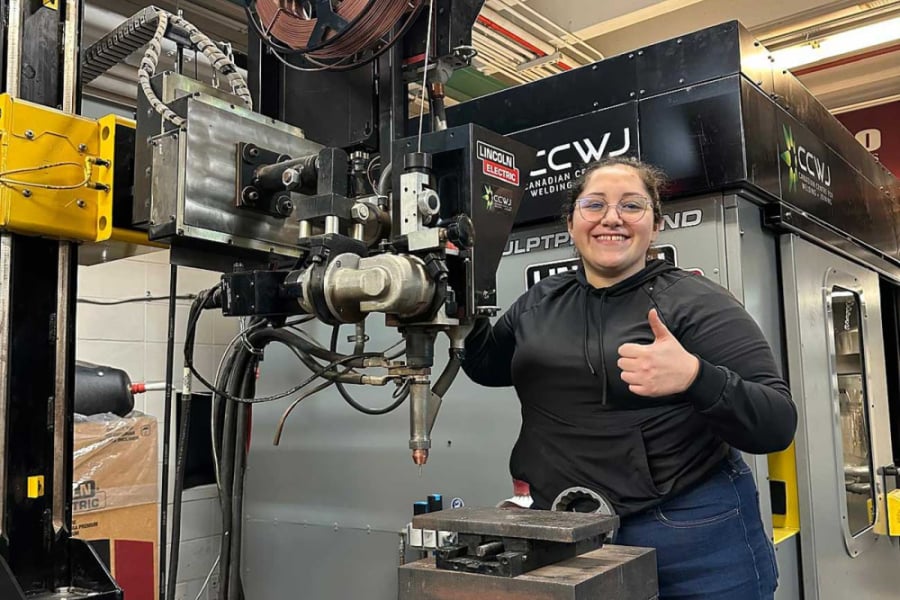 La imagen muestra a la estudiante de magister manipulando una máquina