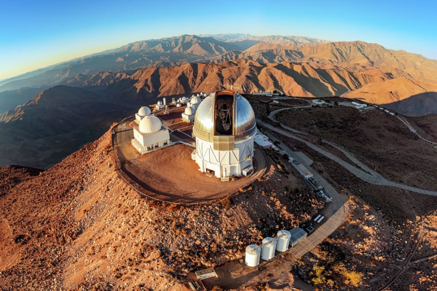 En la imagen aparecen un observatorio en lo alto de una montaña al atardecer.