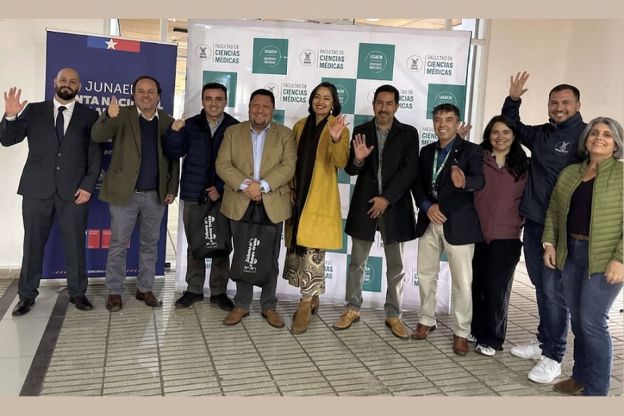 En la imagen aparecen autoridades y académicos FACIMED y de Junji. Posan de forma alegre saludando a la cámara. De fondo, los pendones de las dos entidades.