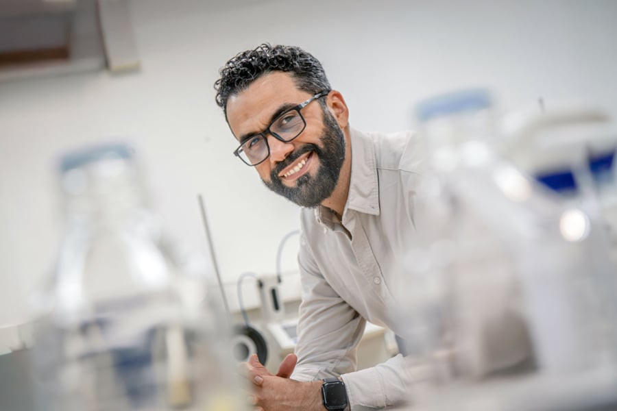 La foto muestra al académico sonriendo en su laboratorio