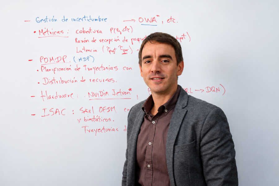 En la imagen aparece el académico, Dr. Karel Toledo, académico del Departamento de Ingeniería Eléctrica. De fondo una pizarra blanca con contenido escrito en rojo y azul.