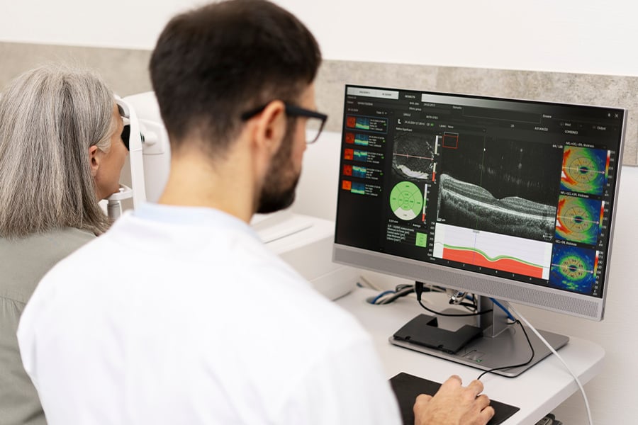 Un médico analiza resultados de exámenes en un monitor mientras examina a un paciente.