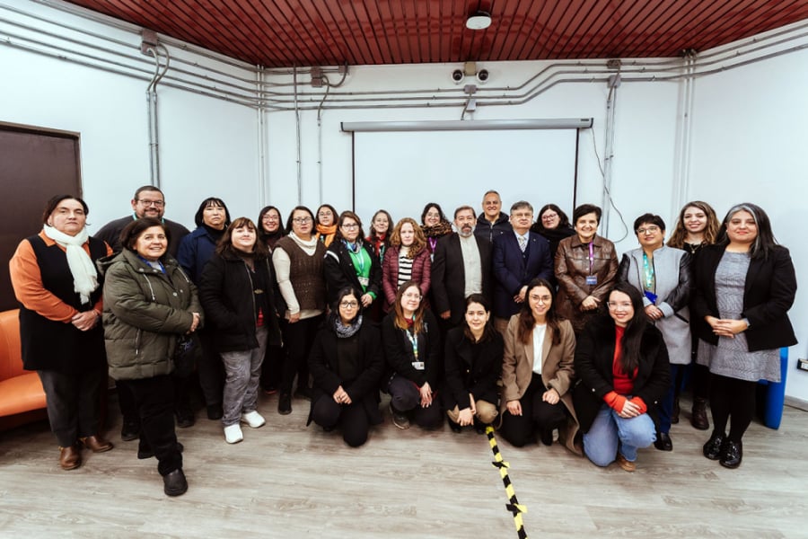 La imagen muestra a las y los asistentes a la actividad, posando en una de las salas de la biblioteca central
