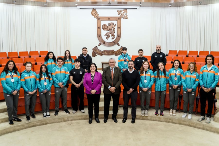 La foto muestra a la delegación deportiva y a los entrenadores en el Salón de Honor. Al centro el rector Palominos, a la derecha la vicerrectora y a la izquierda el jefe del departamento de deportes
