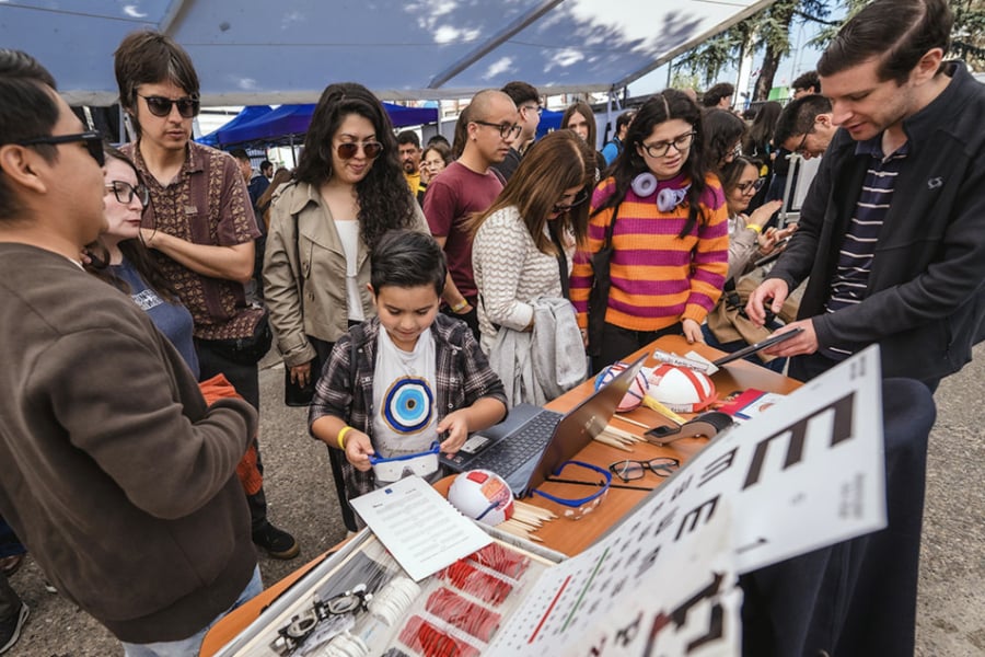 En la imagen aparecen una decenas de personas informándose en un stand de NeuroFest