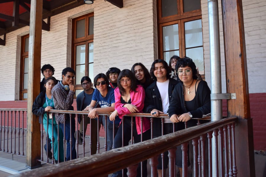 En la imagen aparecen jóvenes actores estudiantes de la agrupación estudiantil Usach en un pasillo del segundo piso de la EAO