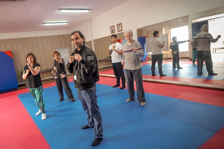 En la imagen aparecen funcionarios Usach que practica Taekwondo en nuestra universidad en postura de combate.