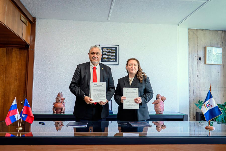 En la imagen aparecen el Rector Usach y la Rectora de la universidad rusa. Están en la oficina rectorial y los dos aparecen mostrando los documentos del acuerdo firmado.